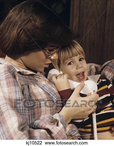 1970S Teenage Babysitter Helping Toddler Speak On Telephone View Large Photo Image Stock Image - 1970S Teenage Babysitter Helping Toddler Speak On Telephone. Fotosearch