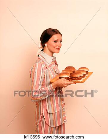 1970S Woman Housewife Holding Tray Of Hamburgers View Large Photo Image Stock Photograph - 1970S Woman Housewife Holding Tray Of Hamburgers . Fotosearch