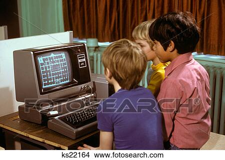 1980S 3 Elementary School Boys Operating Early Radio Shack Trs80 Computer Playing Game View Large Photo Image Picture - 1980S 3 Elementary School Boys Operating Early Radio Shack Trs80 Computer Playing Game. Fotosearch