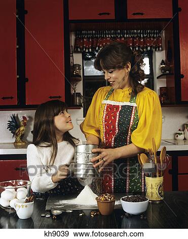 Stock Photo - 1980S Mother And Daughter Baking Sifting Flour In Kitchen. Fotosearch