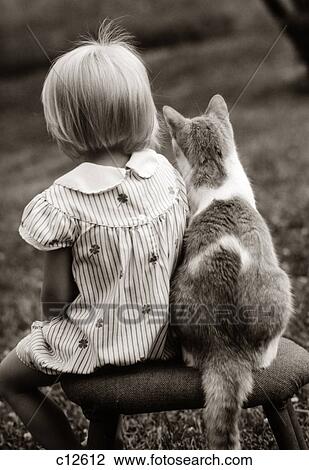 Stock Image - 1980S Rear View Of Little Girl & Cat Sitting Outside On Stool. Fotosearch