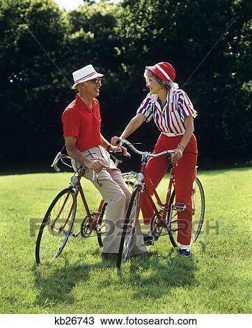 Stock Image - 1980S Senior Man Woman On Bicycles. Fotosearch