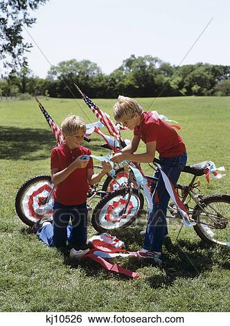 Stock Photograph - 1980S Two Boys Twins Decoration Bikes With Patriotic Crepe Paper And Flags. Fotosearch