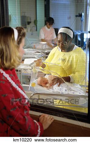 1990S Nurse In Hospital Nursery Showing Baby To Mother Through Window View Large Photo Image Stock Image - 1990S Nurse In Hospital Nursery Showing Baby To Mother Through Window. Fotosearch