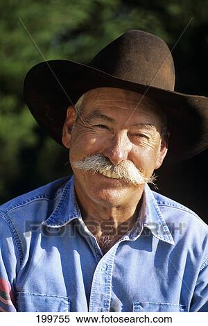 1990S Portrait Of Smiling Cowboy With Gray Mustache Black Hat Blue Shirt Looking At Camera View Large Photo Image Stock Photography - 1990S Portrait Of Smiling Cowboy With Gray Mustache Black Hat Blue Shirt Looking At Camera. Fotosearch