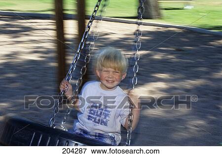 Stock Photo - 1990S Smiling Blond Boy On Tire Swing. Fotosearch