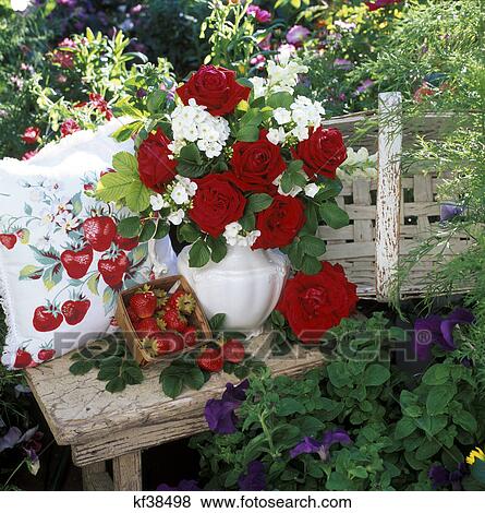 2000s Bouquet De Roses Rouges Et Fleurs Blanches Dans Vase Sur Banc Jardin à Fraises Banque De Photo