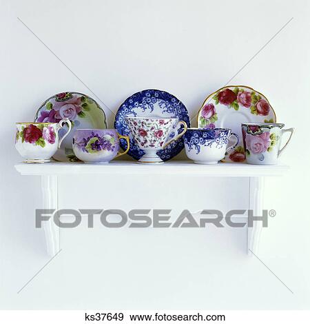 Stock Photo - 2000S Floral Patterned Teacups And Saucers On Mantelpiece White Shelf. Fotosearch