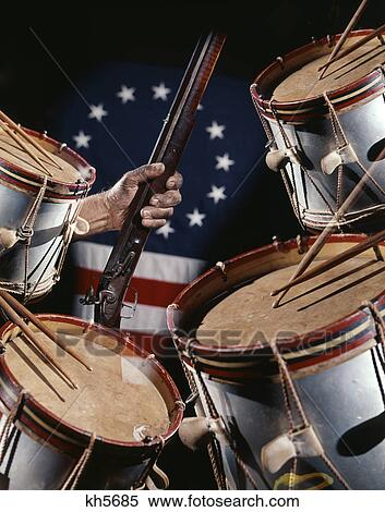 Stock Photography - Hand Holding Flintlock Gun With Colonial 13 Star Flag Drums. Fotosearch