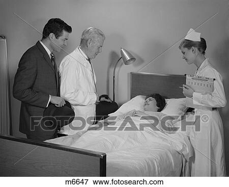 Picture of 1960S Doctor Nurse Husband Talking With Female Patient In ...