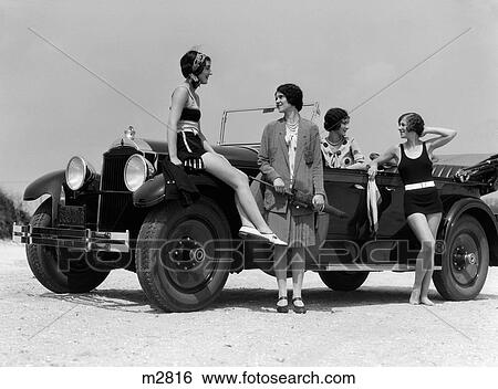 1920S 1930S Four Women Around Convertible Touring Car At Seashore Two In Bathing Suits & Two Dressed For Fashion Outdoor View Large Photo Image Stock Photograph - 1920S 1930S Four Women Around Convertible Touring Car At Seashore Two In Bathing Suits & Two Dressed For Fashion Outdoor. Fotosearch