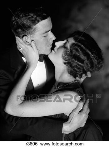 1920S 1930S Romantic Couple Embracing About To Kiss Evening Dress Studio View Large Photo Image Stock Photograph - 1920S 1930S Romantic Couple Embracing About To Kiss Evening Dress Studio . Fotosearch