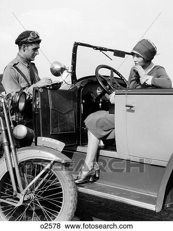 1920S Woman In Car Getting Ticketed By Motorcycle Cop View Large Photo Image Stock Photo - 1920S Woman In Car Getting Ticketed By Motorcycle Cop. Fotosearch
