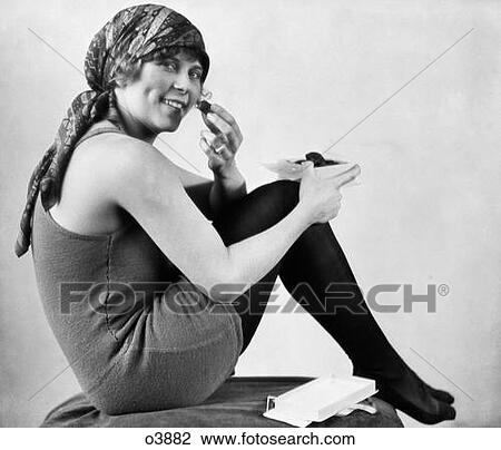 1920S Woman In Old Fashioned Bathing Suit With Scarf On Head Seated With Knees To Chest Eating Chocolates Looking At Camera View Large Photo Image Stock Image - 1920S Woman In Old Fashioned Bathing Suit With Scarf On Head Seated With Knees To Chest Eating Chocolates Looking At Camera. Fotosearch