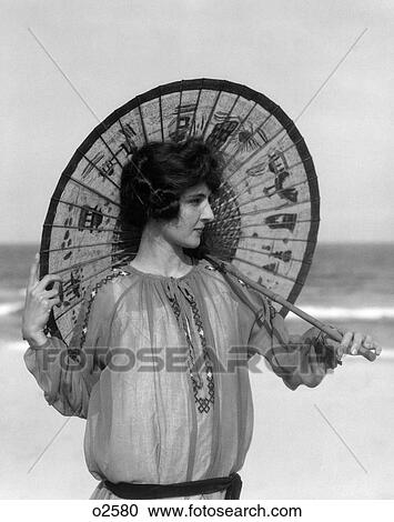 1920S Woman Standing On Beach Holding Oriental Umbrella Looking Off To Side View Large Photo Image Stock Image - 1920S Woman Standing On Beach Holding Oriental Umbrella Looking Off To Side. Fotosearch