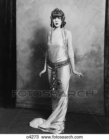 1920S Woman Wearing Exotic Egyptian Inspired Lame Gown Costume With Jeweled Belt Headpiece Fashion  View Large Photo Image Stock Image - 1920S Woman Wearing Exotic Egyptian Inspired Lame Gown Costume With Jeweled Belt Headpiece Fashion . Fotosearch