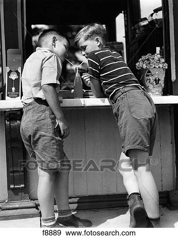 1930S 1940S Boys Sharing A Soda With Two Straws Leaning On Store Counter Side View Summer Outdoor View Large Photo Image Stock Photo - 1930S 1940S Boys Sharing A Soda With Two Straws Leaning On Store Counter Side View Summer Outdoor. Fotosearch