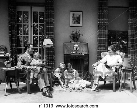 1930S 1940S Family In Living Room Listening To Radio While Children Play With Toy Houses On Floor View Large Photo Image Stock Photo - 1930S 1940S Family In Living Room Listening To Radio While Children Play With Toy Houses On Floor. Fotosearch