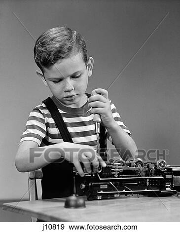 1930S 1940S Little Boy Fixing Lionel Electric Toy Train Engine Using Tool Screwdriver View Large Photo Image Stock Photo - 1930S 1940S Little Boy Fixing Lionel Electric Toy Train Engine Using Tool Screwdriver . Fotosearch