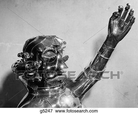 Stock Photo - 1930S 1940S Metal Robot Head And Chest With One Arm Raised And Mouth In A Scowl. Fotosearch