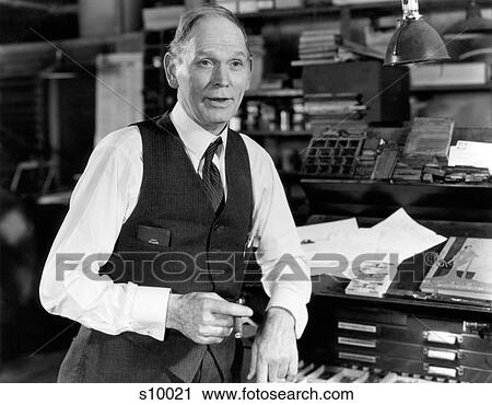 1930S 1940S Older Man Wearing Shirtsleeves Vest Leaning On Type Drawer Cabinet In Old Printing Shop Smoking Cigar And Talking View Large Photo Image Stock Image - 1930S 1940S Older Man Wearing Shirtsleeves Vest Leaning On Type Drawer Cabinet In Old Printing Shop Smoking Cigar And Talking. Fotosearch