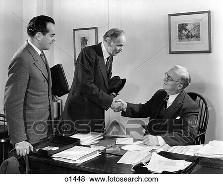 1930S 1940S Two Salesmen Making Sale To Businessman Sitting At Desk Hand Shake To Close The Deal Smiling View Large Photo Image Stock Photo - 1930S 1940S Two Salesmen Making Sale To Businessman Sitting At Desk Hand Shake To Close The Deal Smiling . Fotosearch
