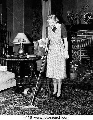 1930S 1940S Woman Housewife Wearing Apron Pushing Electric Vacuum Cleaner In Ornate Living Room House Chore View Large Photo Image Stock Photograph - 1930S 1940S Woman Housewife Wearing Apron Pushing Electric Vacuum Cleaner In Ornate Living Room House Chore. Fotosearch