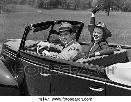 1930S Couple In Convertible Wearing Hats With Gloved Woman Waving At Camera Smiling Looking At Camera View Large Photo Image Stock Photo - 1930S Couple In Convertible Wearing Hats With Gloved Woman Waving At Camera Smiling Looking At Camera. Fotosearch