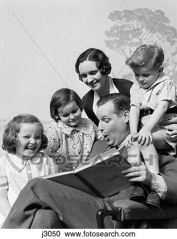 Stock Image - 1930S Family Of Five Grouped Around Father Reading Children'S Punch Book. Fotosearch
