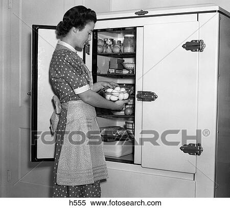 1930S Housewife In Apron Taking Eggs Out Of Bowl From Icebox View Large Photo Image Stock Photography - 1930S Housewife In Apron Taking Eggs Out Of Bowl From Icebox. Fotosearch