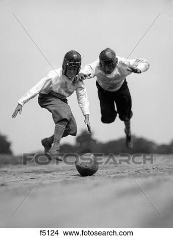 1930S Pair Of Boys In Knickers & Leather Helmets Racing To Dive On Football View Large Photo Image Picture - 1930S Pair Of Boys In Knickers & Leather Helmets Racing To Dive On Football. Fotosearch
