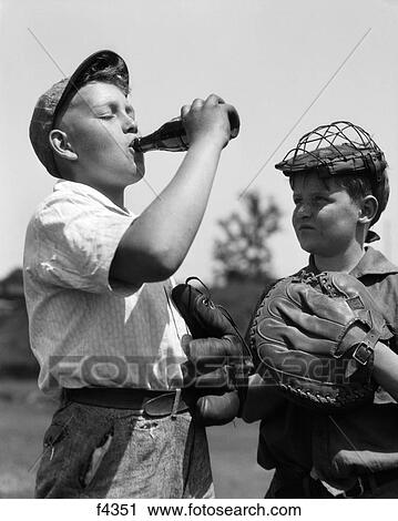 1930S Pair Of Boys Wearing Baseball Gloves One With Catcher'S Mask Watching Other Wearing Cap Drink Bottle Of Soda View Large Photo Image Stock Image - 1930S Pair Of Boys Wearing Baseball Gloves One With Catcher'S Mask Watching Other Wearing Cap Drink Bottle Of Soda. Fotosearch