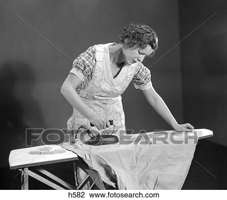 1930S Tired Woman Housewife Wearing Apron Ironing Shirt With Electric Iron On Ironing Board View Large Photo Image Stock Image - 1930S Tired Woman Housewife Wearing Apron Ironing Shirt With Electric Iron On Ironing Board. Fotosearch