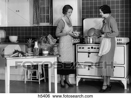 1930S Woman Housewife And Friend Wearing Apron Cooking Food In Kitchen On Gas Stove Indoor View Large Photo Image Stock Photograph - 1930S Woman Housewife And Friend Wearing Apron Cooking Food In Kitchen On Gas Stove Indoor. Fotosearch