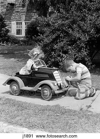 1940S 1930S Boy On Sidewalk Fixing Headlight Of Toy Car Driven By Little Girl Playing Outdoor View Large Photo Image Stock Image - 1940S 1930S Boy On Sidewalk Fixing Headlight Of Toy Car Driven By Little Girl Playing Outdoor. Fotosearch