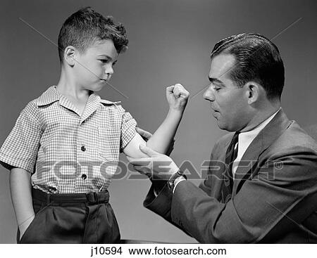 Picture - 1940S Boy Makes Muscle For Man Father. Fotosearch