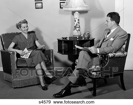 1940S Couple Seated In Living Room Reading Husband Wife Talking To Each Other View Large Photo Image Stock Photo - 1940S Couple Seated In Living Room Reading Husband Wife Talking To Each Other. Fotosearch