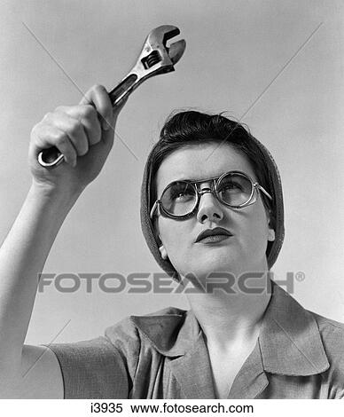 1940S Rosie The Riveter Wearing Safety Glasses Holding Up Monkey Wrench View Large Photo Image Stock Photography - 1940S Rosie The Riveter Wearing Safety Glasses Holding Up Monkey Wrench. Fotosearch