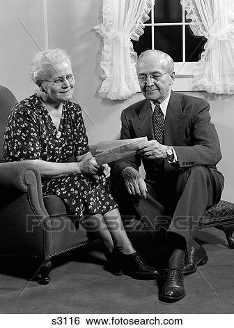 1940S Senior Couple Reading Mail Together In Living Room Husband Wife Indoor View Large Photo Image Stock Photograph - 1940S Senior Couple Reading Mail Together In Living Room Husband Wife Indoor. Fotosearch