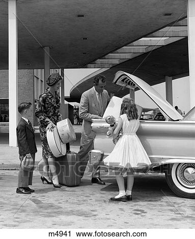 Stock Image - 1950S 1960S Family Of Four Packing Automobile Trunk With Luggage & Hatboxes. Fotosearch