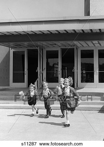 1950S 1960S Four Young Children With Bags And Lunch Boxes Running From School Entrance Smiling View Large Photo Image Stock Photo - 1950S 1960S Four Young Children With Bags And Lunch Boxes Running From School Entrance Smiling . Fotosearch