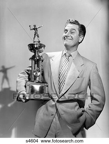 Picture - 1950S 1960S Proud Man Smiling Holding A Football Trophy Looking At Camera. Fotosearch