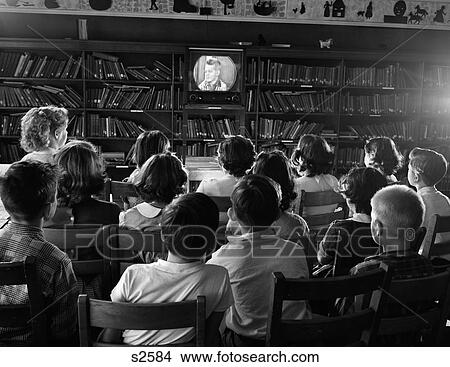 1950S Back View Of Kids In School Library Watching Tv Screen View Large Photo Image Picture - 1950S Back View Of Kids In School Library Watching Tv Screen. Fotosearch