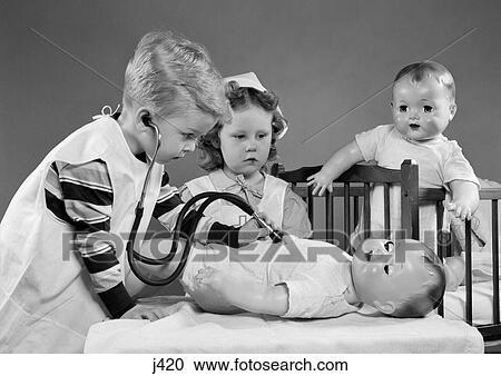 Stock Image - 1950S Boy And Girl Playing Doctor And Nurse With Stethoscope And Dolls . Fotosearch