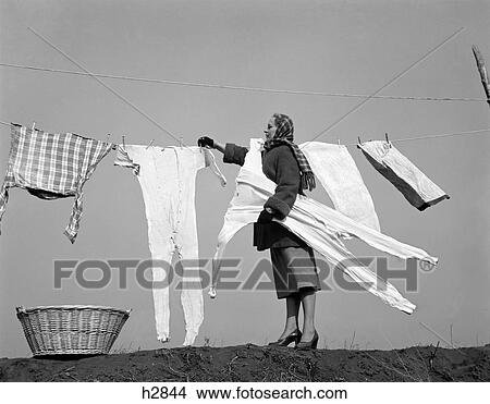 1950S Housewife Removing Frozen Long Johns From Clothesline View Large Photo Image Picture - 1950S Housewife Removing Frozen Long Johns From Clothesline. Fotosearch
