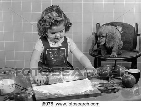 1950S Little Girl Rolling Out Apple Pie Crust On Kitchen Table With Cocker Spaniel Puppy Watching View Large Photo Image Stock Photograph - 1950S Little Girl Rolling Out Apple Pie Crust On Kitchen Table With Cocker Spaniel Puppy Watching. Fotosearch