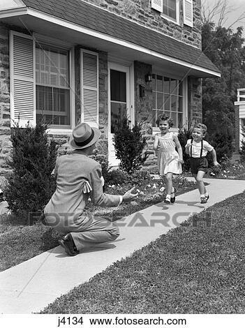 1950S Man Father Arms Out Kneeling In Front Of Suburban Home To Greet Happy Running Welcome Home Son And Daughter View Large Photo Image Picture - 1950S Man Father Arms Out Kneeling In Front Of Suburban Home To Greet Happy Running Welcome Home Son And Daughter. Fotosearch