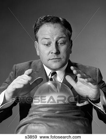 1950S Man In Suit & Tie Looking Down At Crystal Ball With Hands Hovering Over It View Large Photo Image Stock Photo - 1950S Man In Suit & Tie Looking Down At Crystal Ball With Hands Hovering Over It. Fotosearch