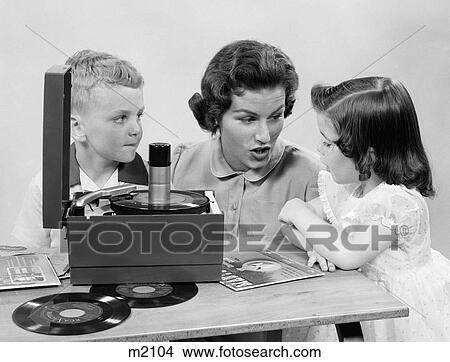 Picture - 1950S Mother Daughter & Son Listening To 45'S On Portable Record Player. Fotosearch