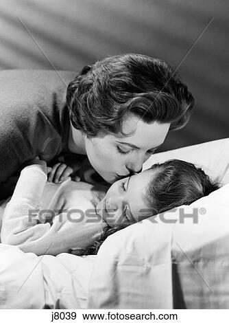 Stock Photo - 1950S Mother Giving Daughter A Goodnight Kiss. Fotosearch